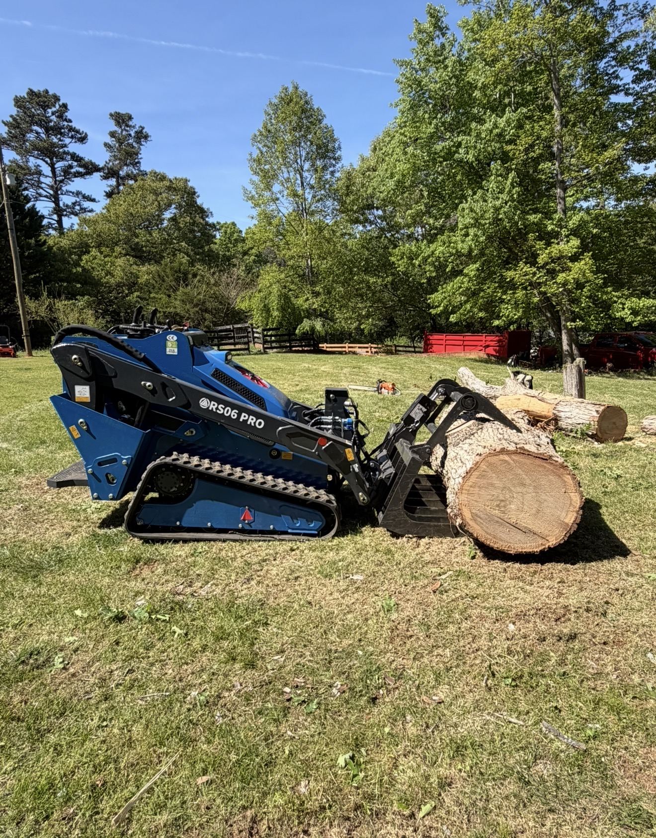 Rippa RS06 Pro mini skid steer carrying a large log in a root grapple